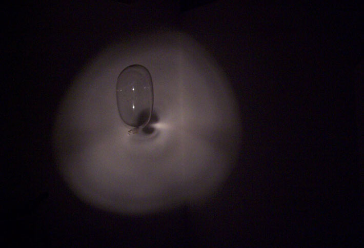 Ein Condom erscheint im dunkeln Raum; Foto